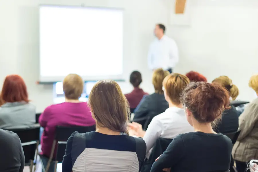 People attending a presentation in a seminar room.